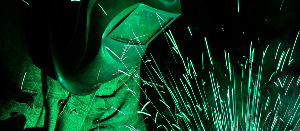ASME Certified Welder with sparks from welding at Cypress Fabrication Services