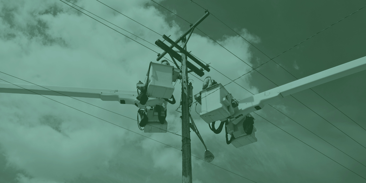 Photo of a power pole with two utility workers in boom buckets in Lafayette LA 