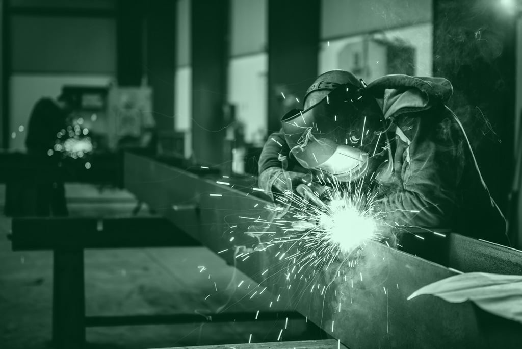 DNV Certified welder welding metal beam at Cypress Fabrication's DNV Certified facility